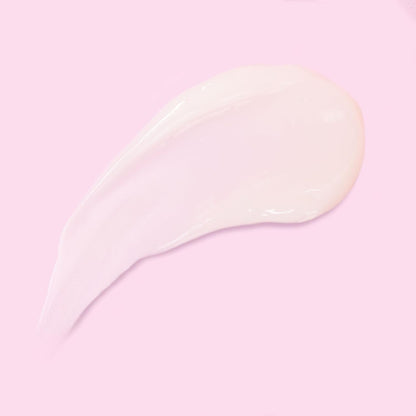 Close-up of a pale cream balm swatch on a pink background